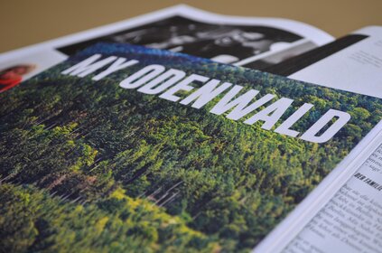 Titelbild des Magazins My Odenwald, das einen Wald zeigt. Im Hintergrund sieht man das aufgeklappte Magazin.